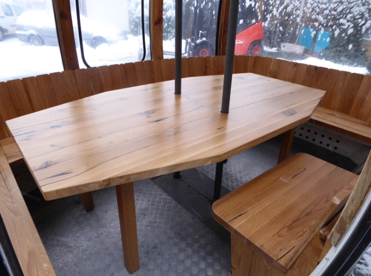 Holztisch mit umlaufender Sitzbank in ausgebauter Gondel – individuelle Innenausstattung aus Massivholz für Gondeln und Hütten.